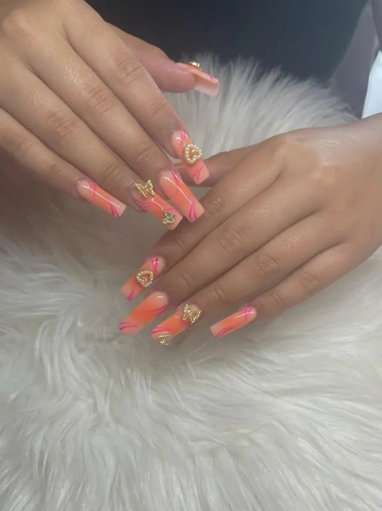 Coral ombre coffin nails with gold butterfly and heart charms
